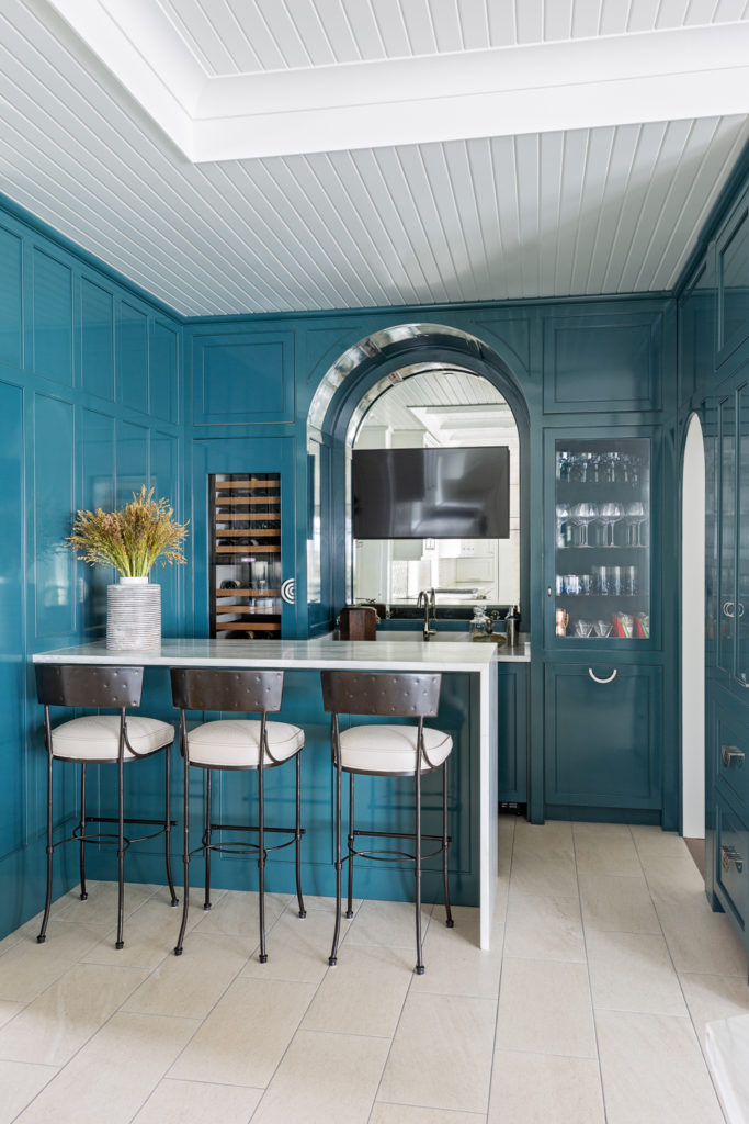 Separate bar space with deep teal lacquered walls and barstools