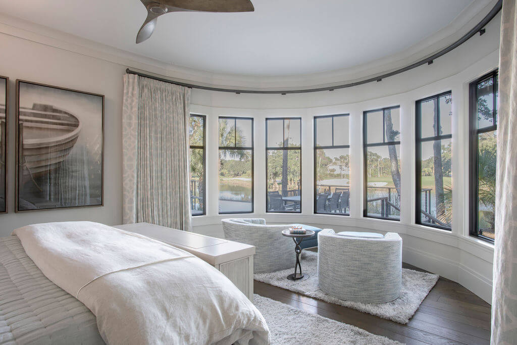 A sitting area of a master suite with large windows and a view of the Lowcountry.