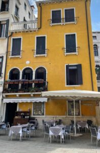 Yellow building with outdoor seating in Italy
